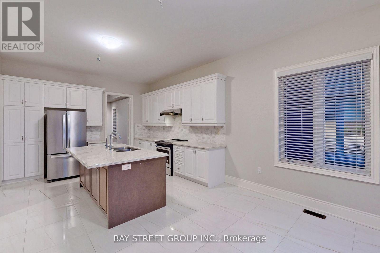 A kitchen with white cabinets and a wooden island.