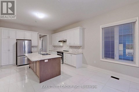 A kitchen with white cabinets and a wooden island.
