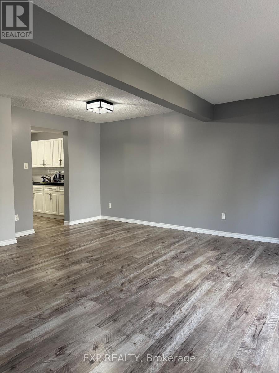 A room with wooden flooring and a white door in the background.