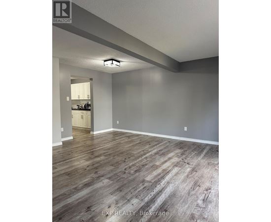 A room with wooden flooring and a white door in the background.