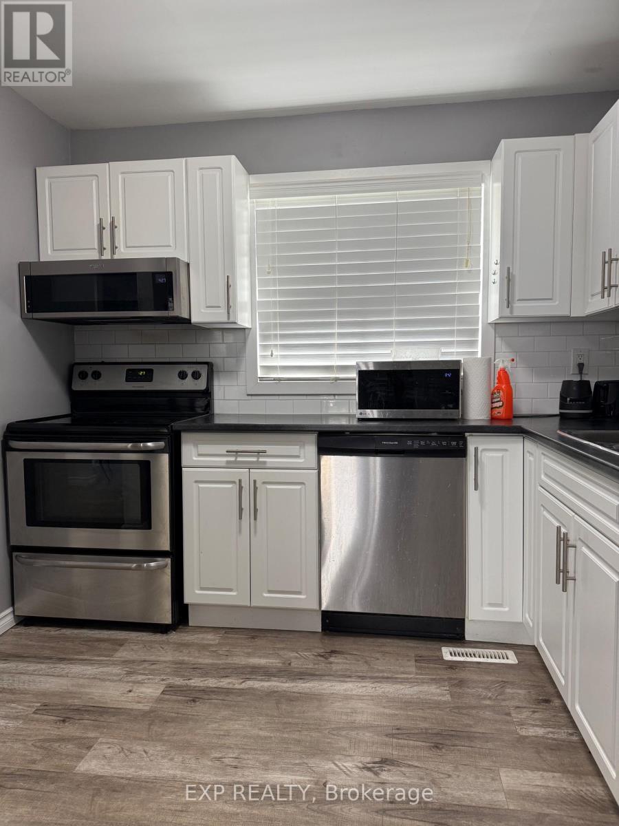 A kitchen with white cabinets and stainless steel appliances.