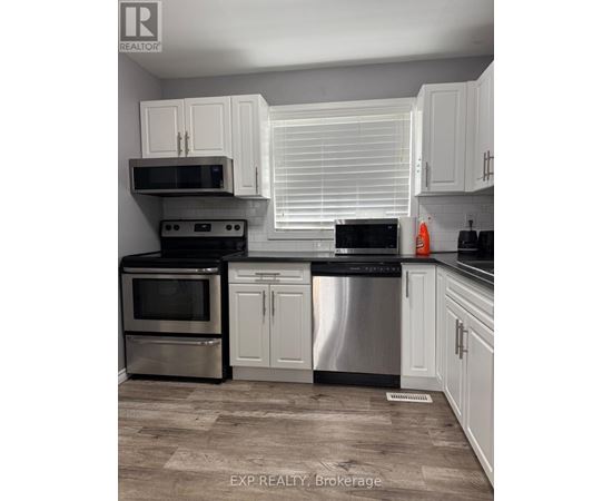 A kitchen with white cabinets and stainless steel appliances.