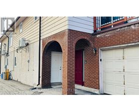 A red door is on the left side of a white garage door.