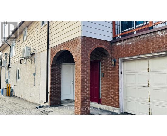 A red door is on the left side of a white garage door.