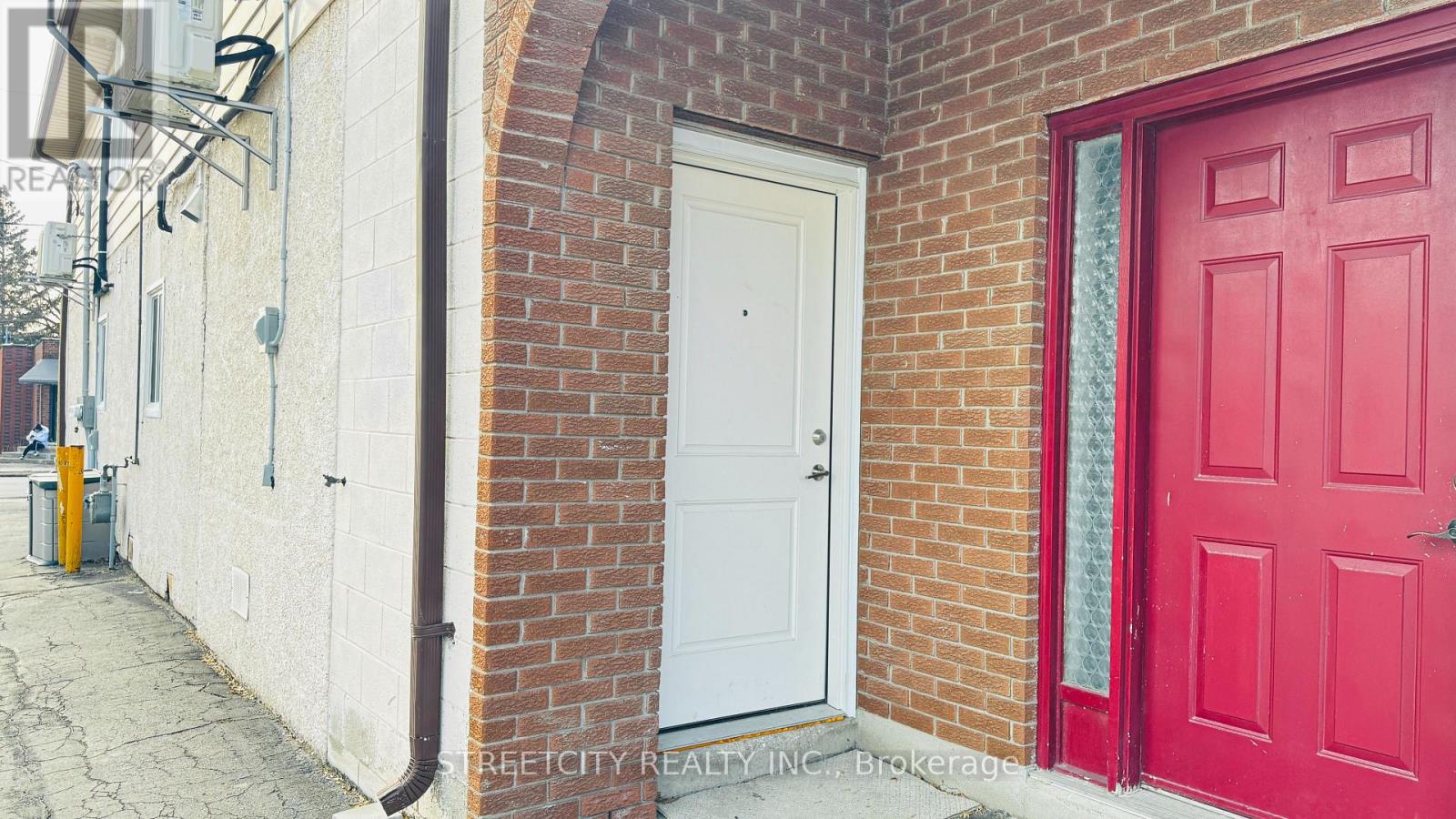 A red door is on the right side of a white door.