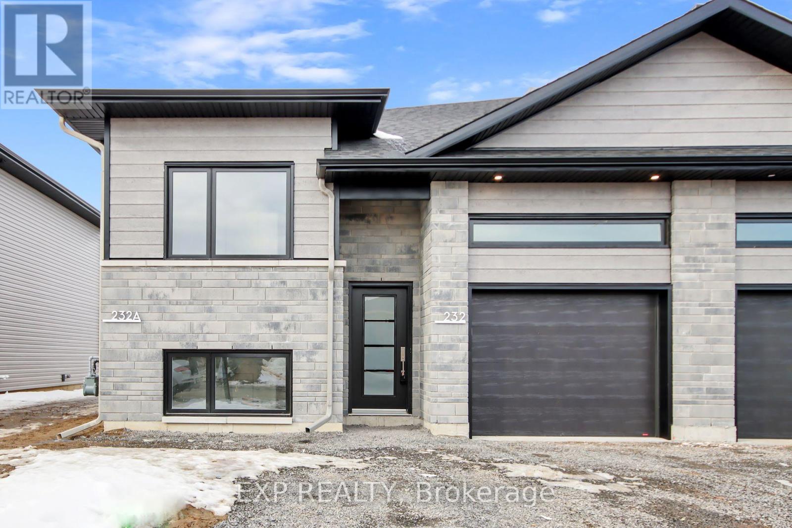 A modern house with a grey exterior and a black door.
