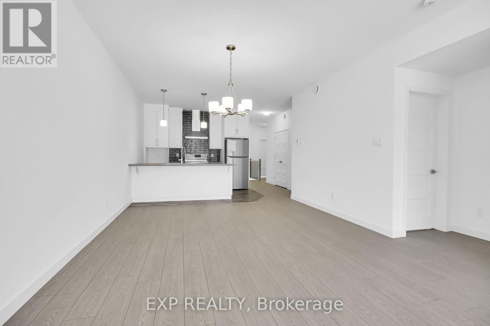 A large, empty room with wooden floors and white walls.