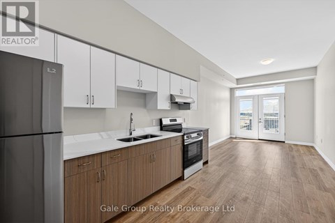 A modern kitchen with wooden cabinets and a refrigerator.