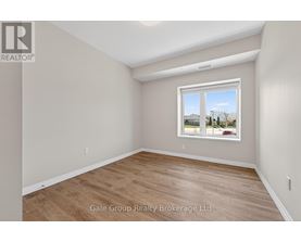 A room with a window showing a view of houses and trees outside.