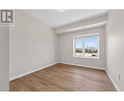 A room with a window showing a view of houses and trees outside.