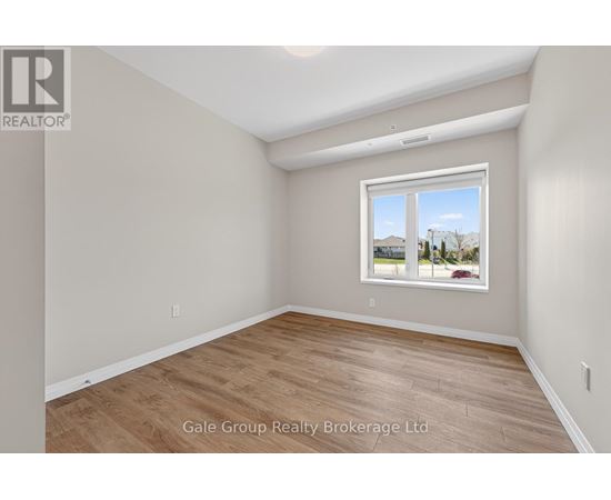 A room with a window showing a view of houses and trees outside.