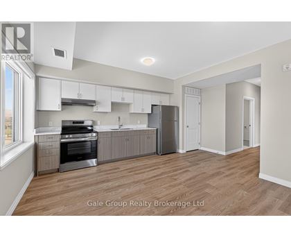 A spacious kitchen with white cabinets and stainless steel appliances.