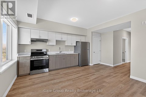 A spacious kitchen with white cabinets and stainless steel appliances.