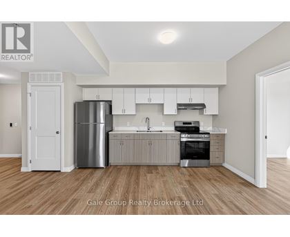 A modern kitchen with white cabinets and stainless steel appliances.