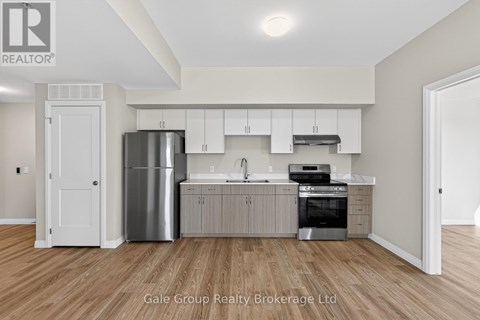 A modern kitchen with white cabinets and stainless steel appliances.