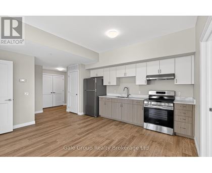 A kitchen with white cabinets and a stainless steel refrigerator.