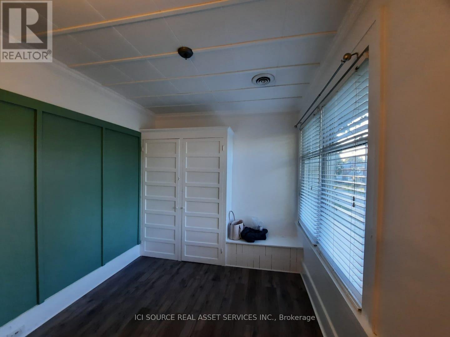 A room with a white ceiling, a green wall, and a white closet.