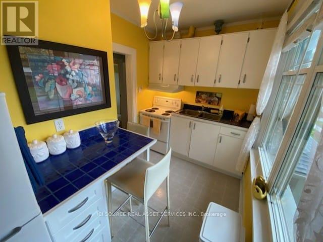 A kitchen with white cabinets and a blue counter.