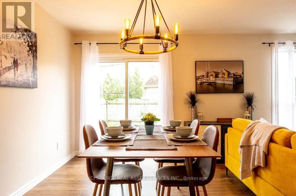 A dining room with a table set for six and a yellow couch.