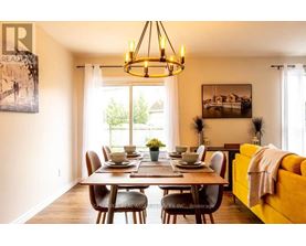 A dining room with a table set for six and a yellow couch.