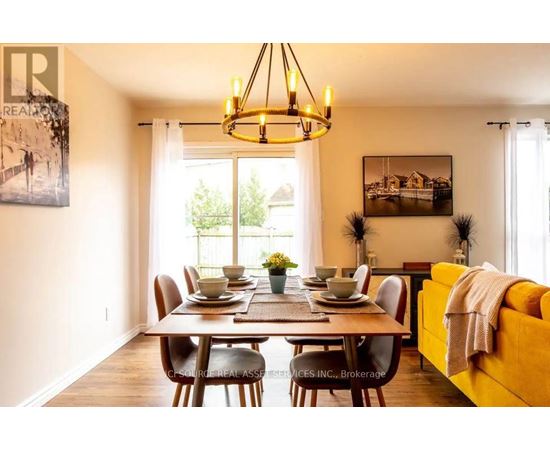A dining room with a table set for six and a yellow couch.