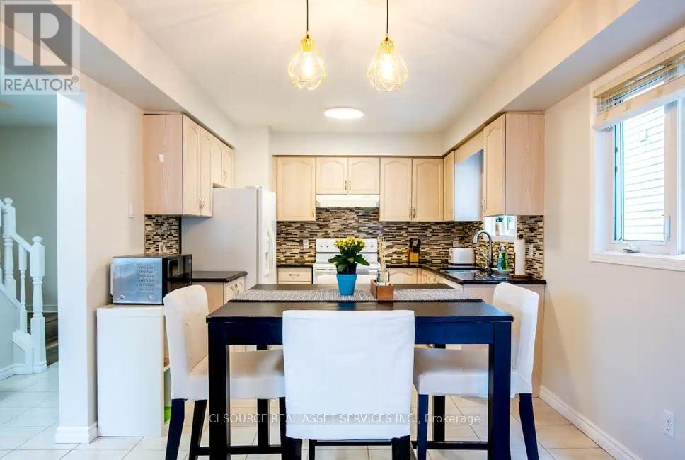 A kitchen with a dining table and chairs.