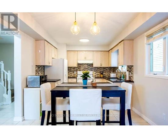 A kitchen with a dining table and chairs.