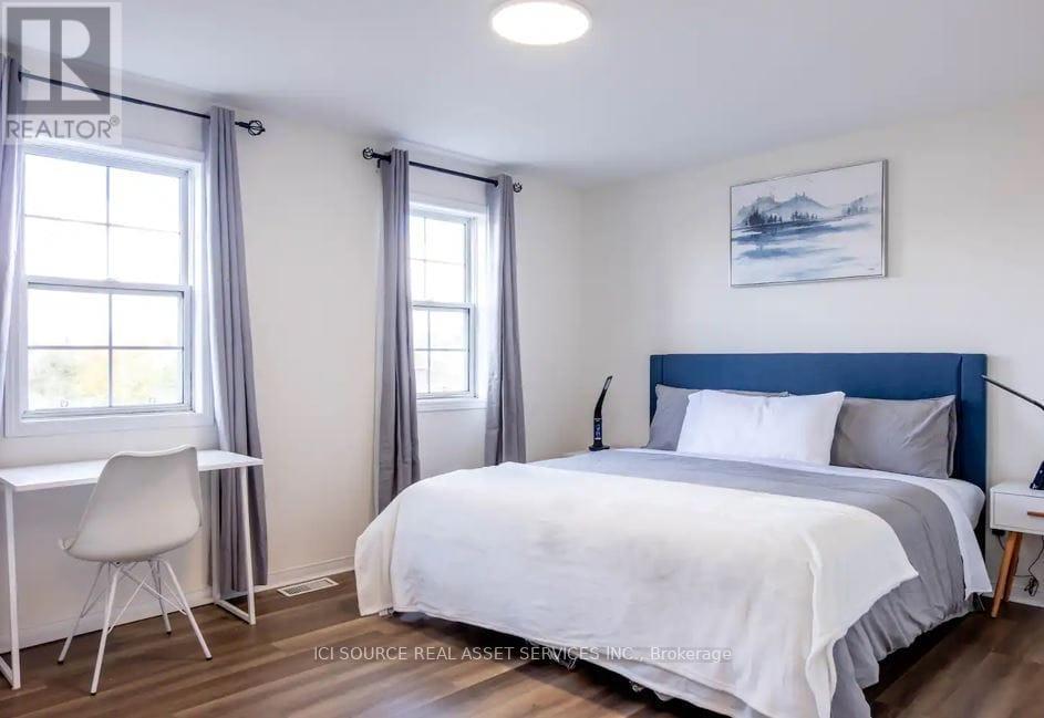 A bedroom with a bed, desk, and chair.