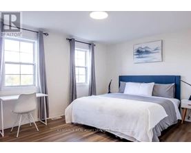 A bedroom with a bed, desk, and chair.