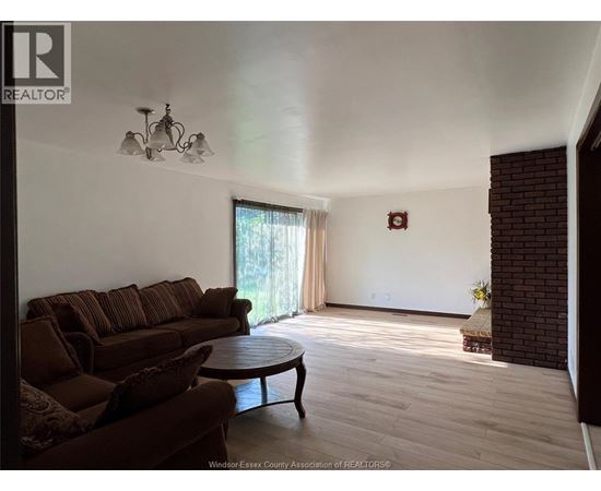 A living room with a brown couch and a round table.