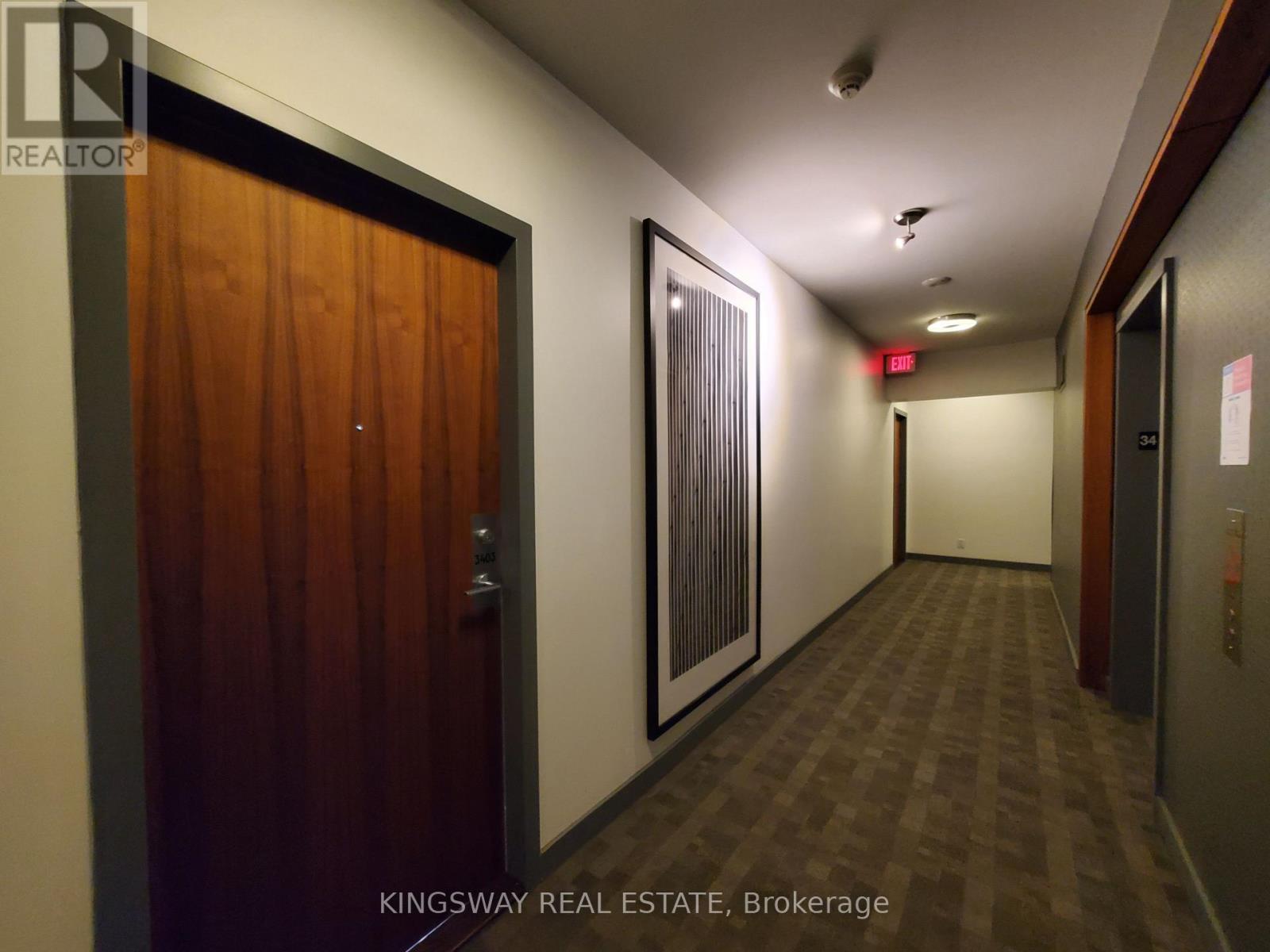 A hallway with a door on the left and a window on the right.