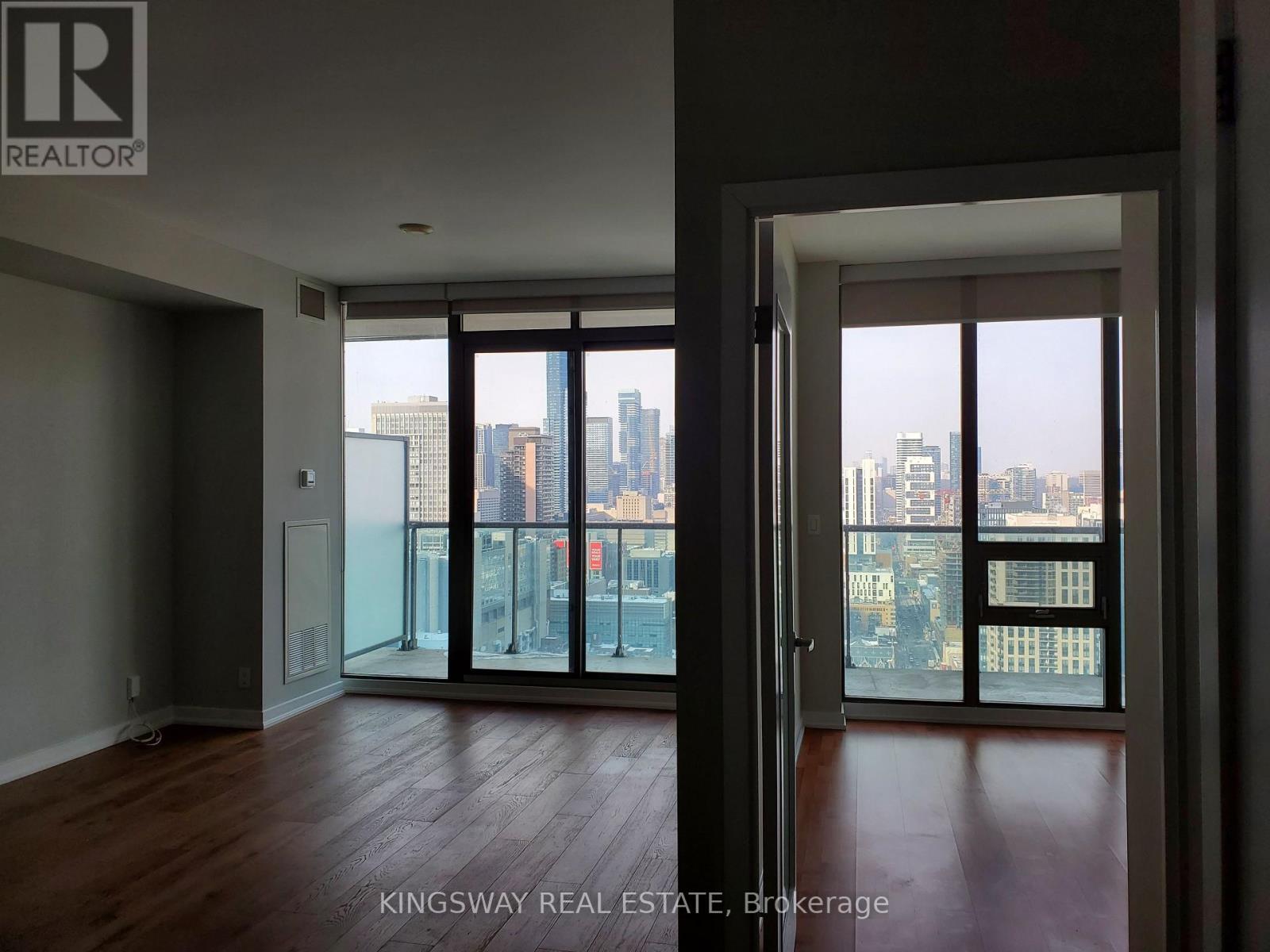 A room with a view of the city through large windows.