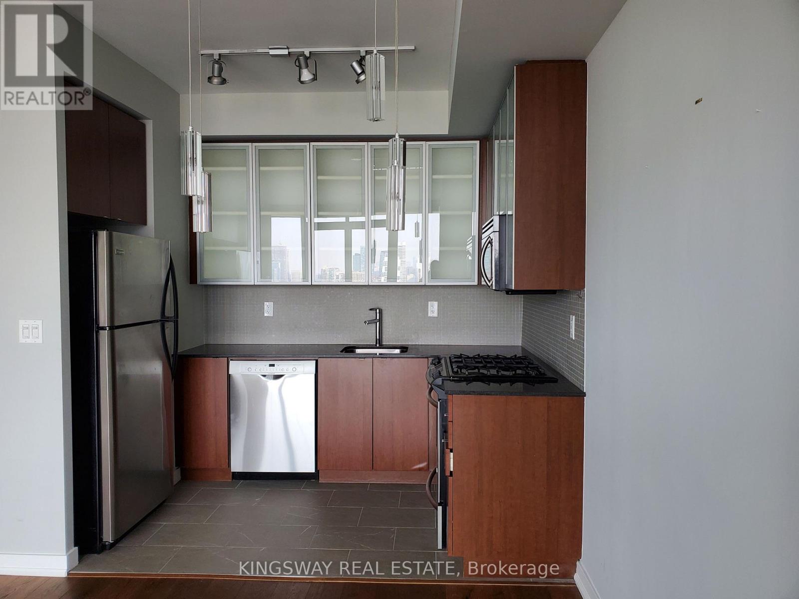 A kitchen with a sink, dishwasher and refrigerator.