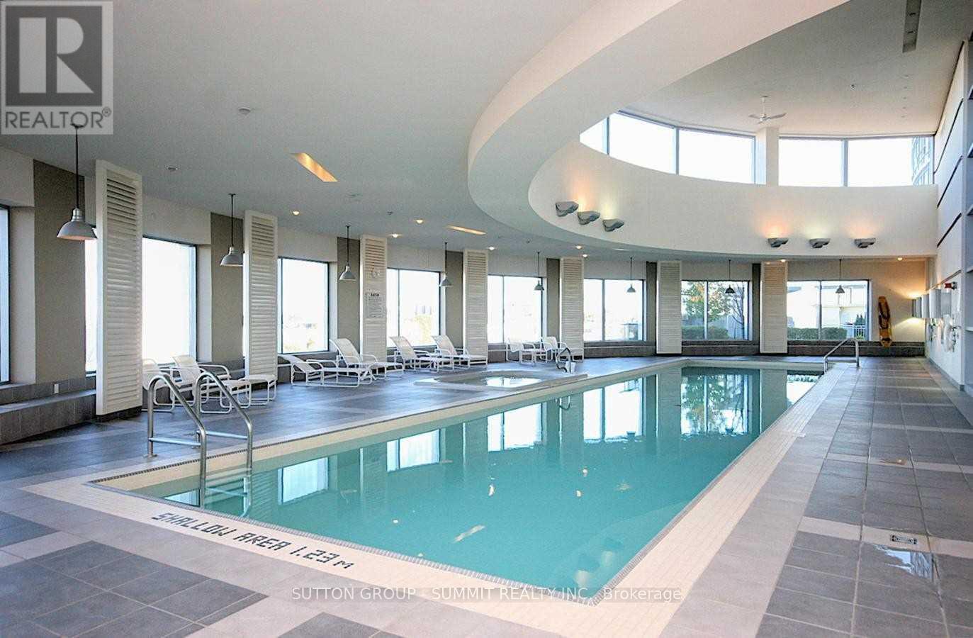 A large indoor swimming pool with a sunken seating area.