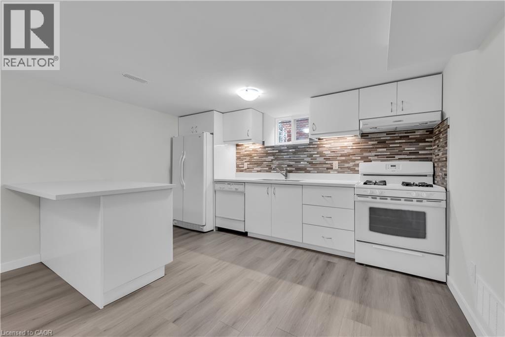A modern kitchen with white appliances and a stone backsplash.