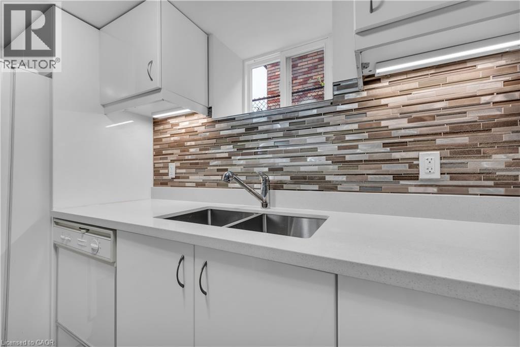 A modern kitchen with a white countertop and a brick backsplash.
