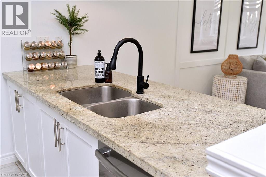 A kitchen with a sink and a bottle of Meyer lemon.