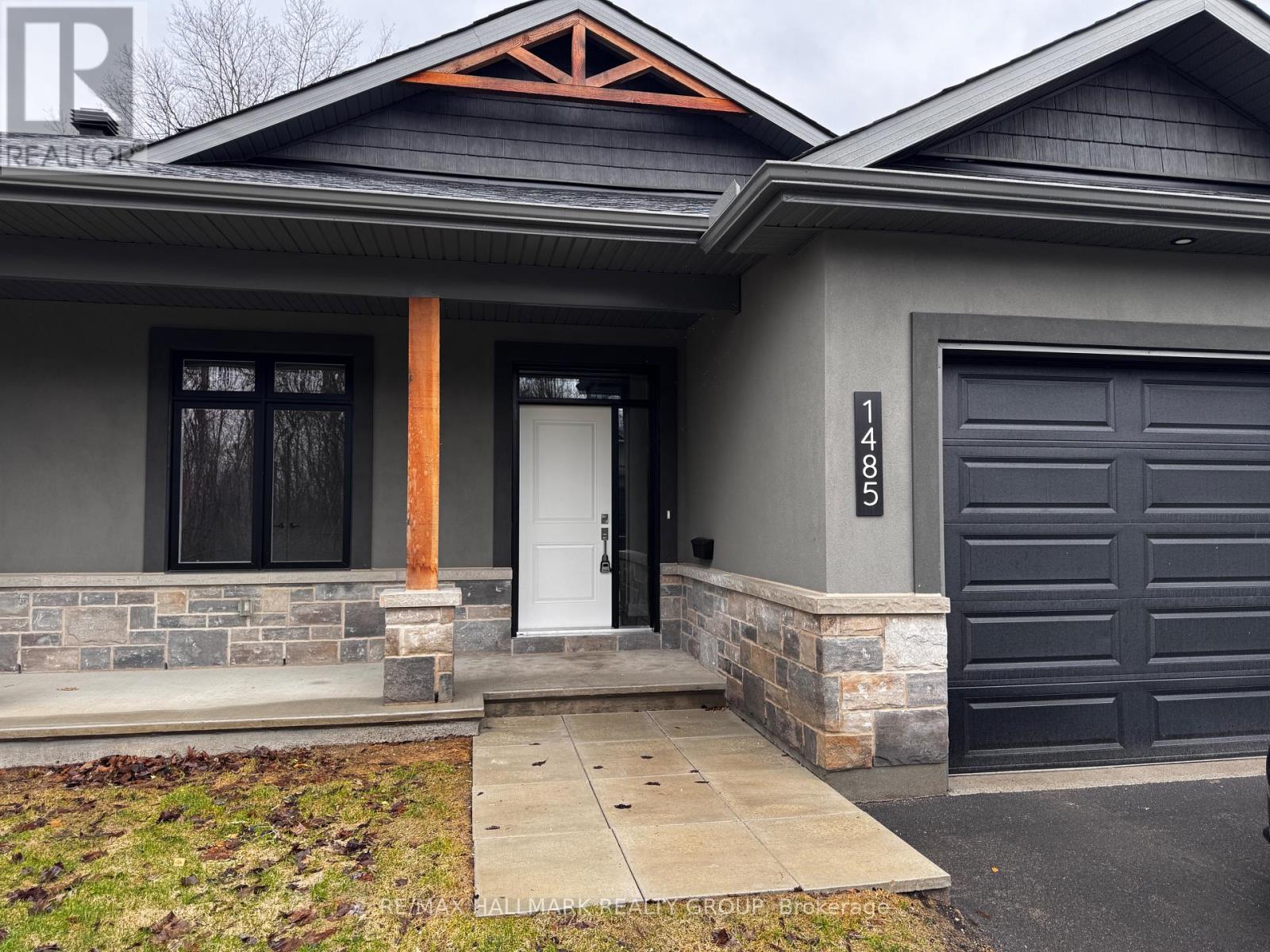 A house with a grey front and a black garage door.