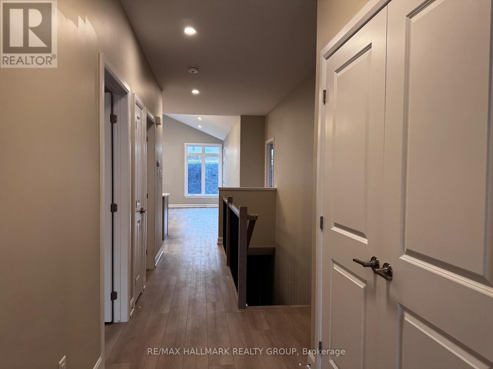 A hallway with white doors and a wooden floor.