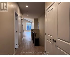 A hallway with white doors and a wooden floor.