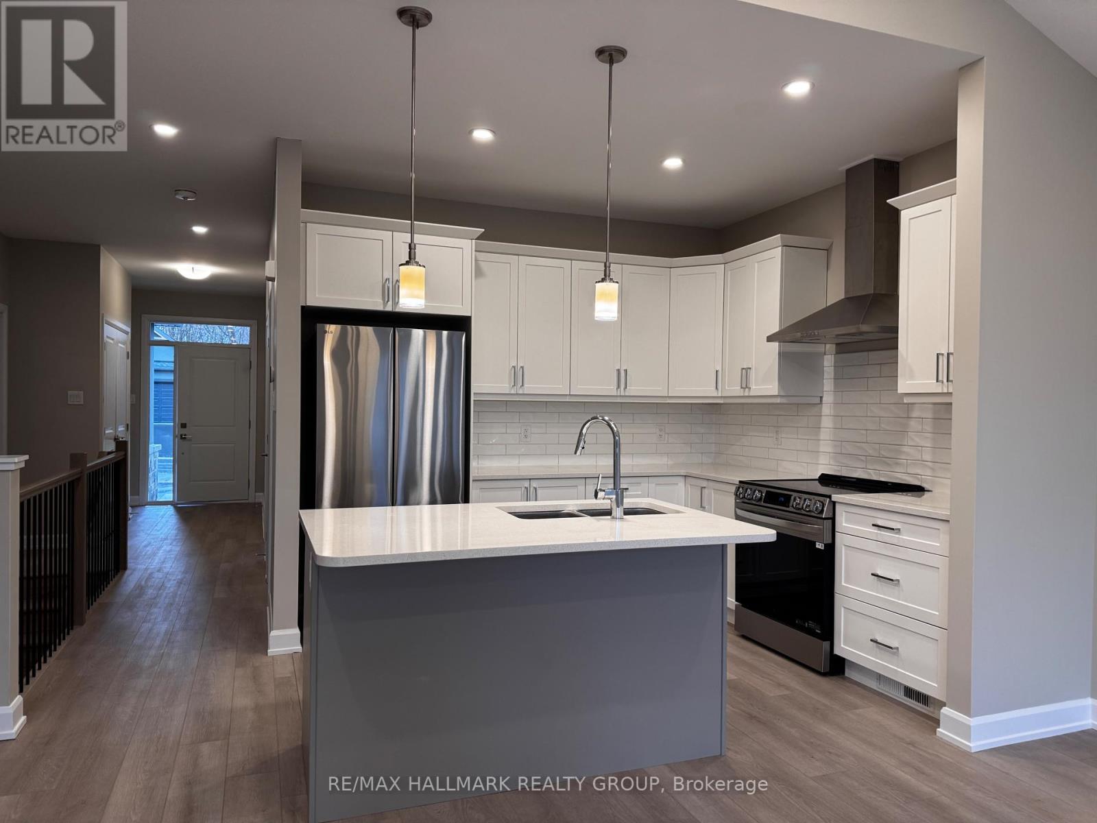 A modern kitchen with a large island and stainless steel appliances.