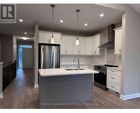A modern kitchen with a large island and stainless steel appliances.