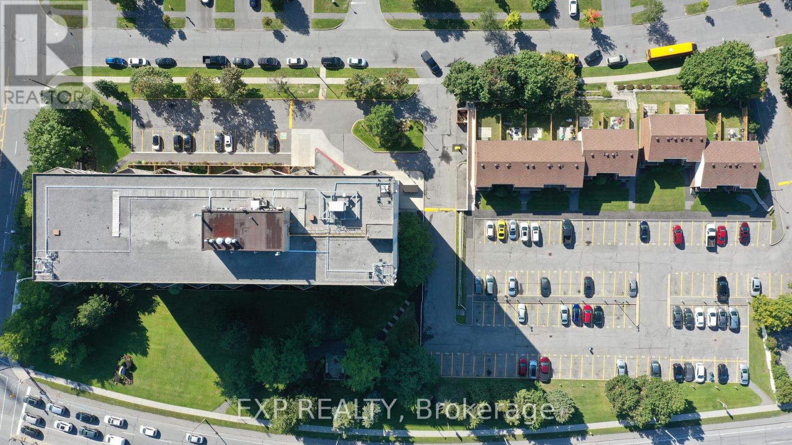 An aerial view of a parking lot with a building and a sign that says "EXPRESALTY Brokerage".
