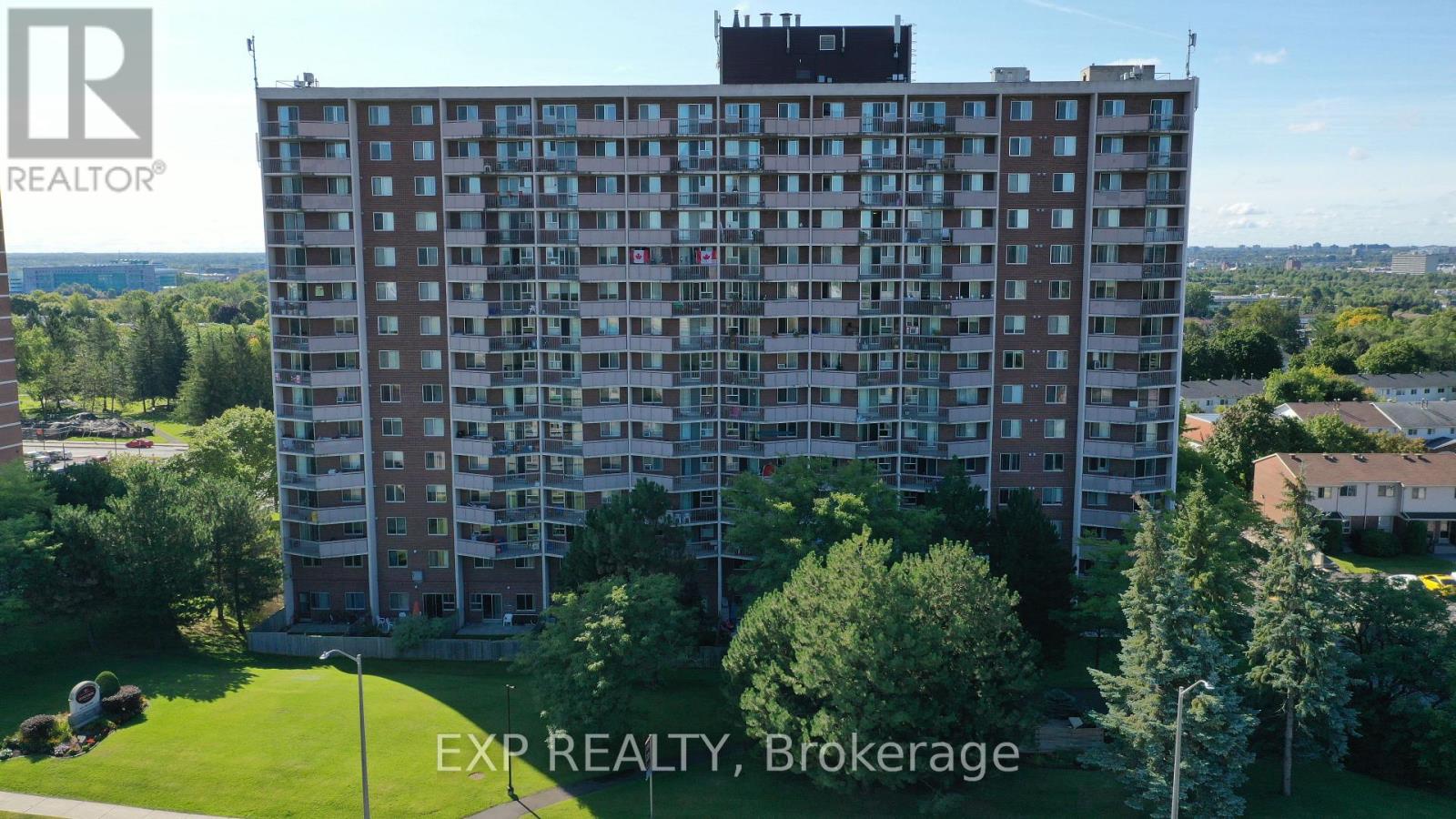 A tall residential building with a green lawn in front.