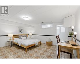 A bedroom with a bed, desk, and chair.