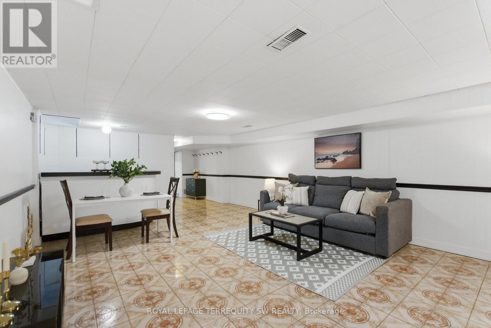 A living room with a grey couch, a coffee table, and a painting on the wall.