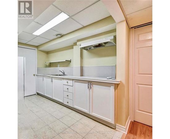 A kitchen with white cabinets and a white refrigerator.