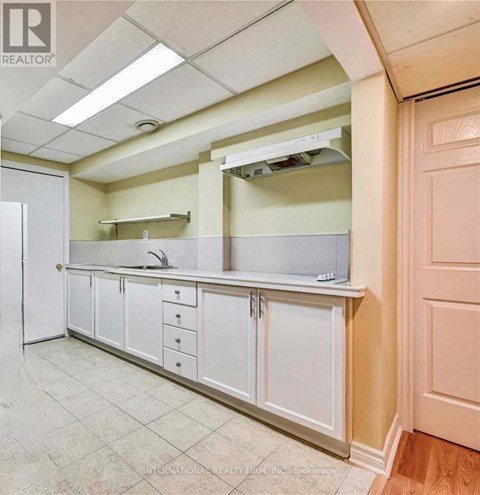 A kitchen with white cabinets and a white refrigerator.