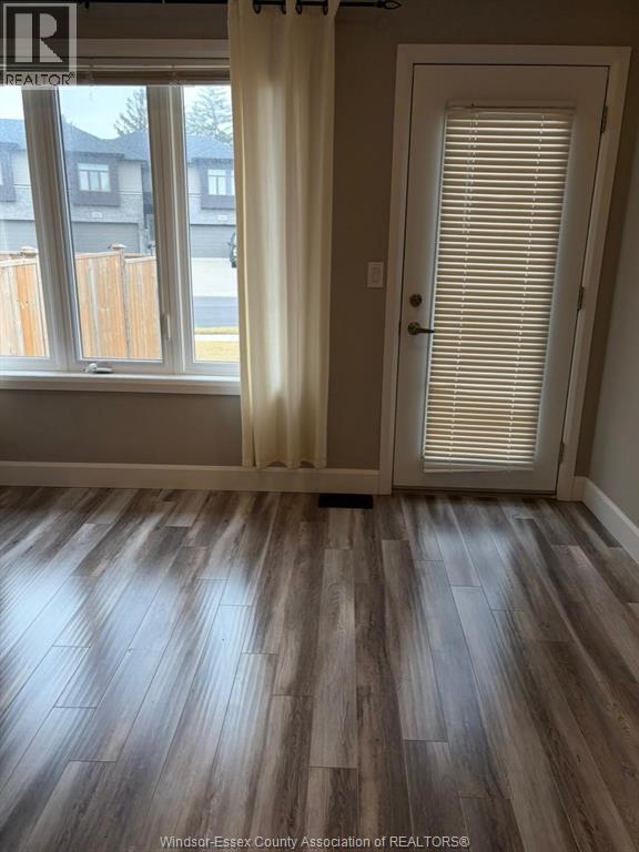 A room with a wooden floor and a window with blinds.