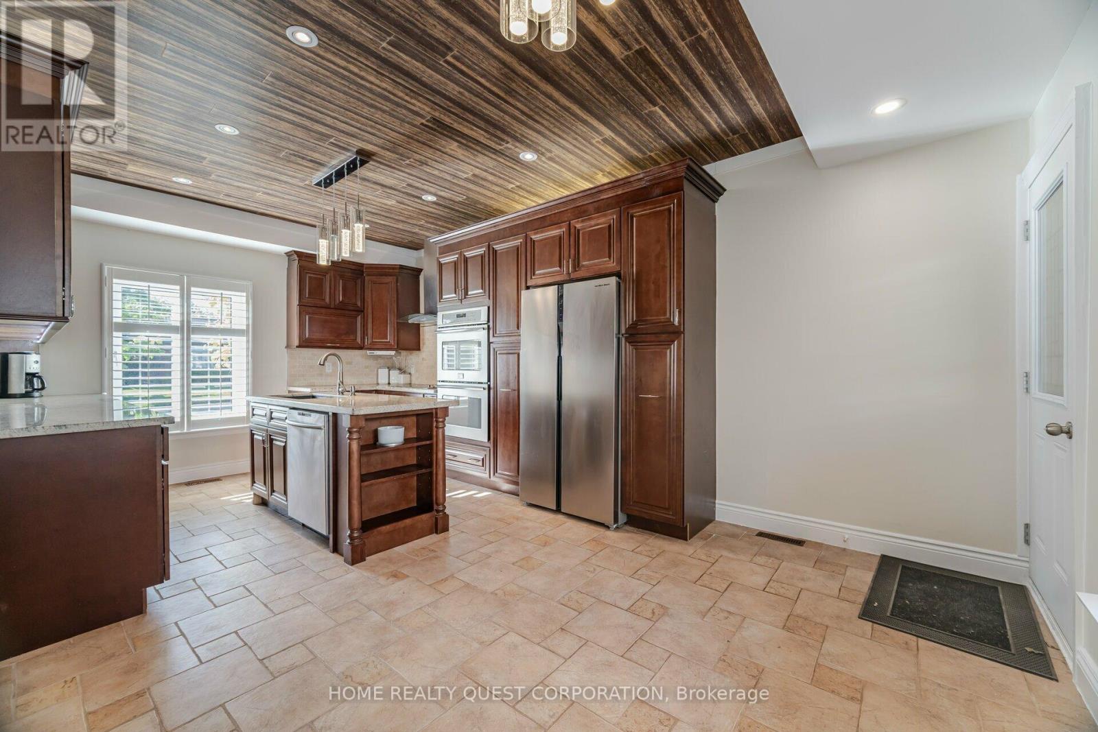 A kitchen with wooden cabinets and a tiled floor.